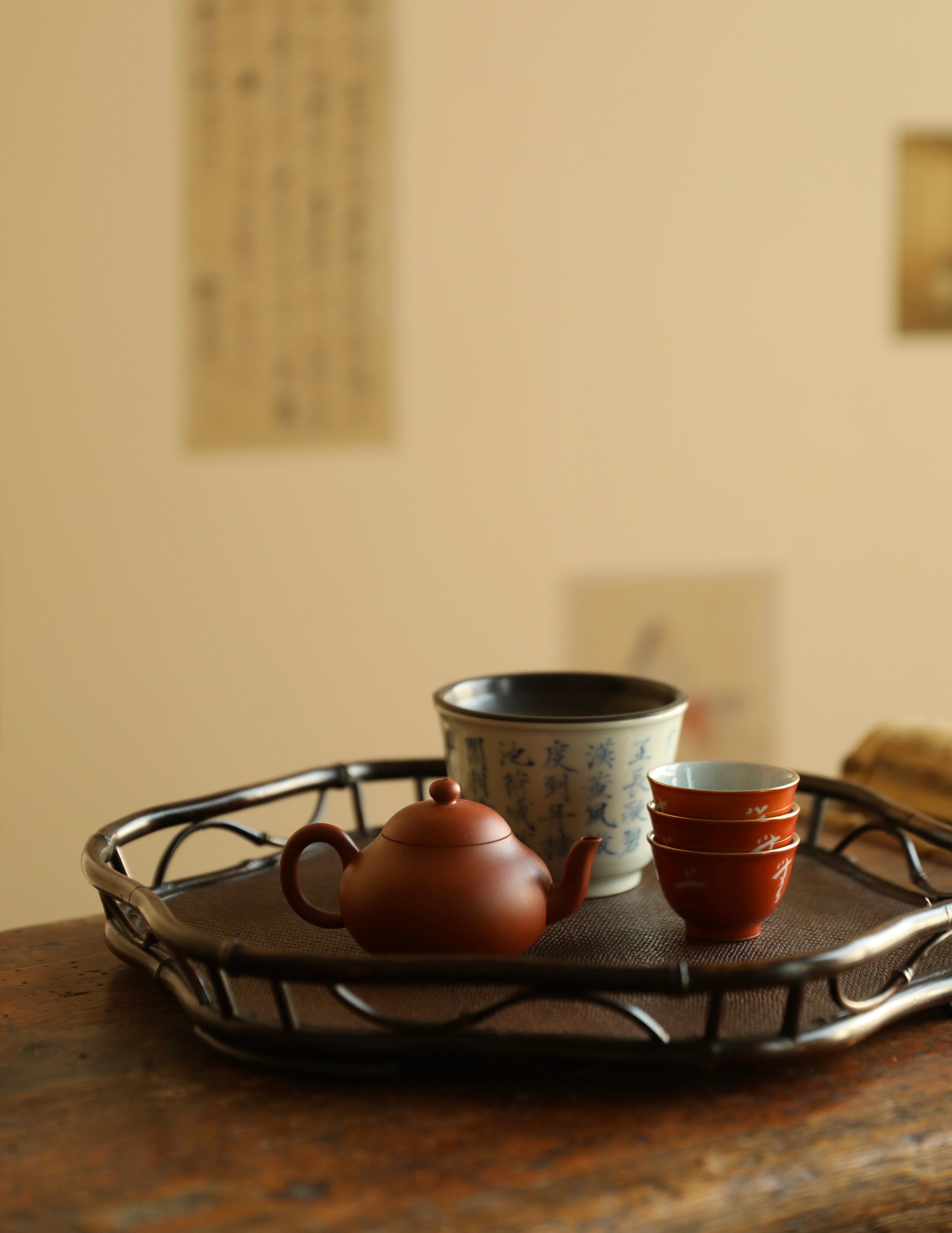 The Shirabe Bamboo Tray by Piexlculpt is a handcrafted tea tray combining purple bamboo and rattan weaving in a plum blossom frame design. Its light yet sturdy form embodies balance and grace