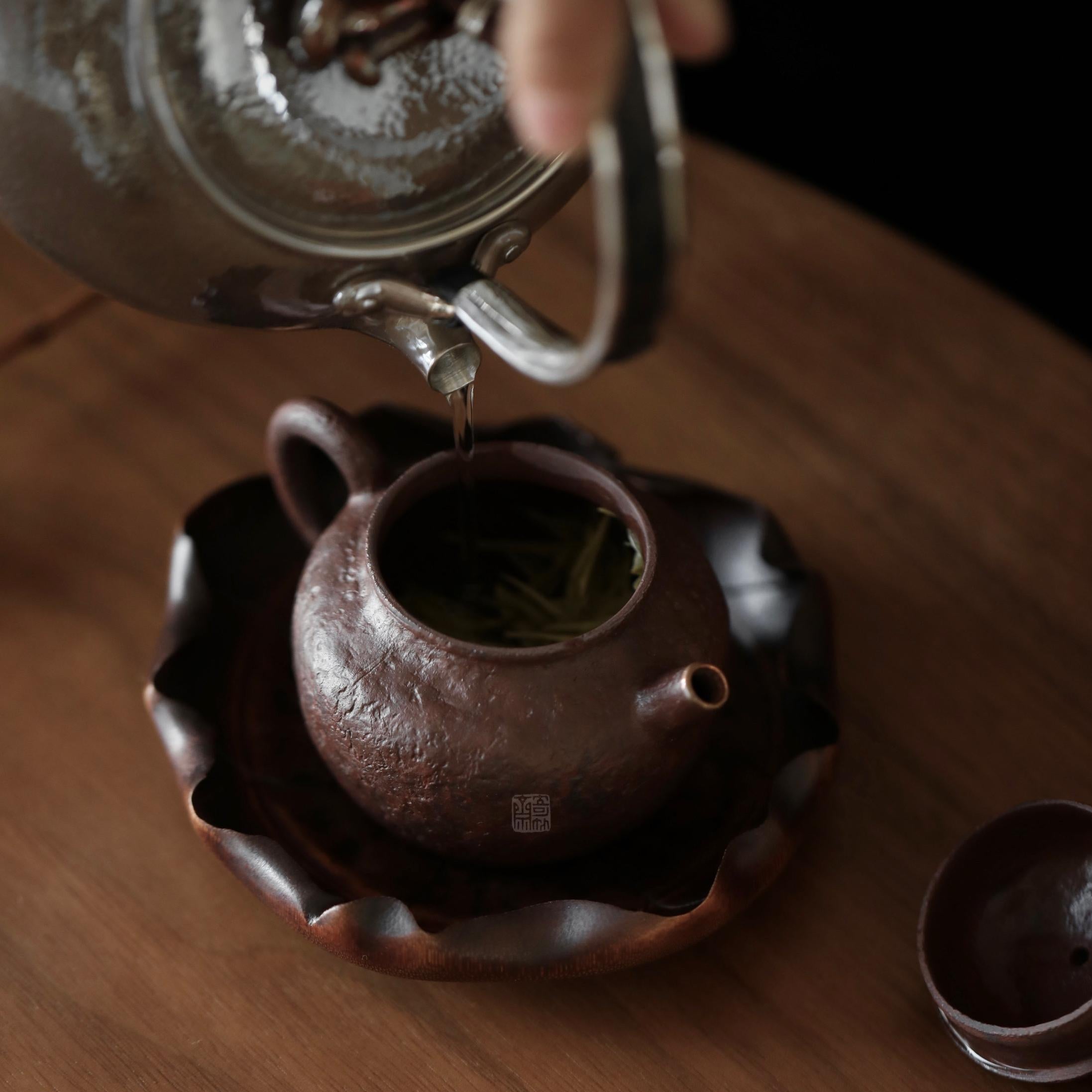 The Hasu Bamboo Tea Holder by Piexlculpt features a handcrafted lotus-leaf design made from aged bamboo and natural lacquer. Its hand-shaped curves and organic texture celebrate the beauty of imperfection