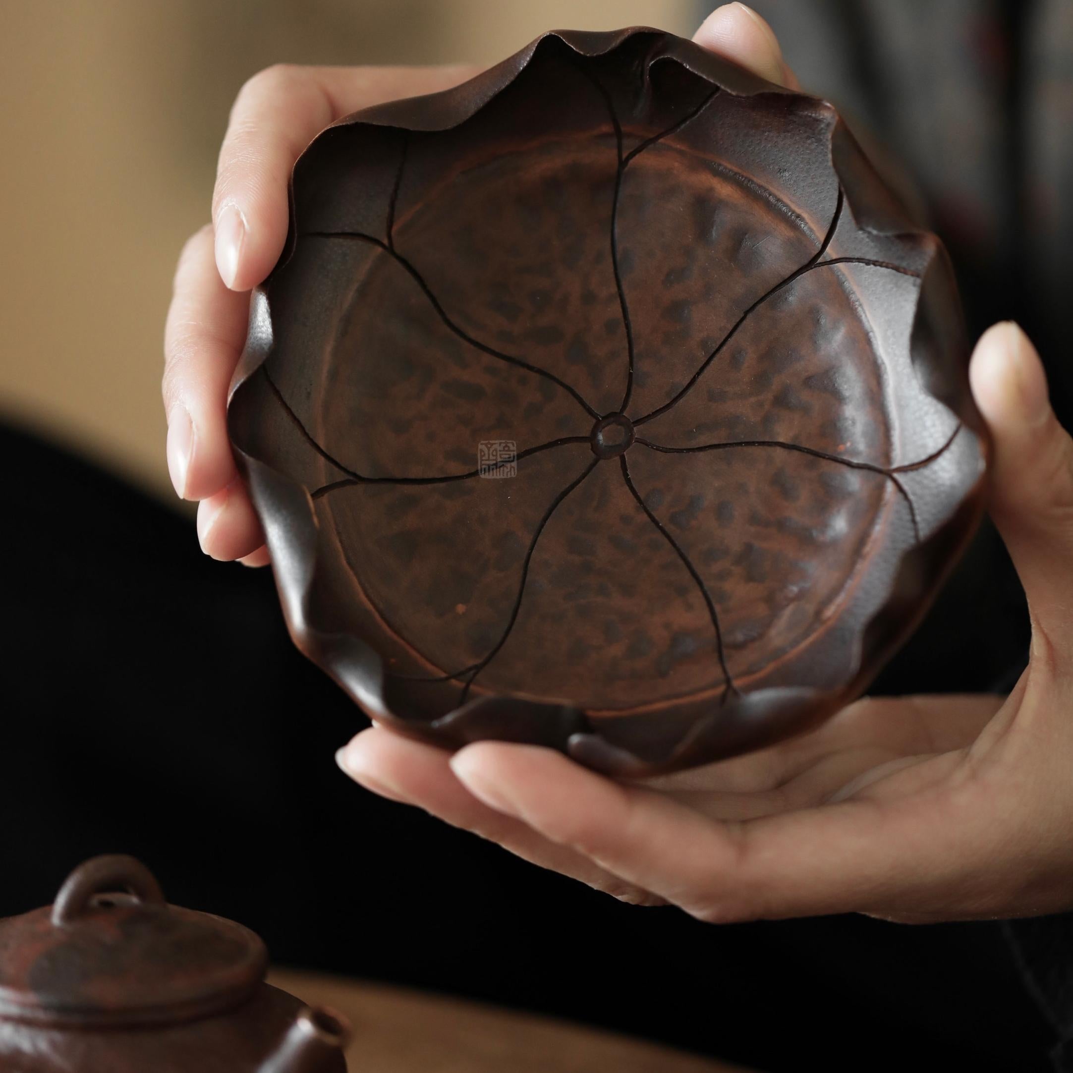 The Hasu Bamboo Tea Holder by Piexlculpt features a handcrafted lotus-leaf design made from aged bamboo and natural lacquer. Its hand-shaped curves and organic texture celebrate the beauty of imperfection