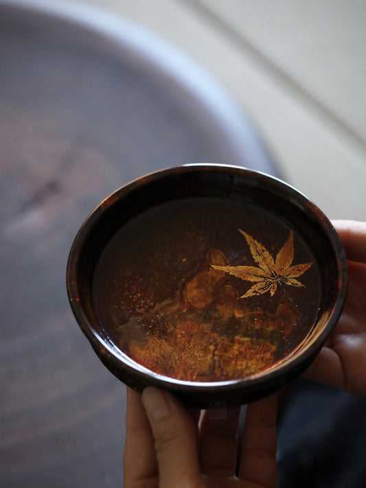 The Maple Lacquer Tray by Piexlculpt is a handcrafted tea tray made with natural lacquer and a delicate maple leaf gold-foil finish. Its handmade texture and subtle shine evoke timeless serenity, ideal for tea ceremonies