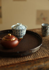 The Kosei Woven Bamboo Tray by Piexlculpt is crafted by hand from natural bamboo, offering two unique finishes: deep purple bamboo and warm brown bamboo. Its circular woven design reflects the calm