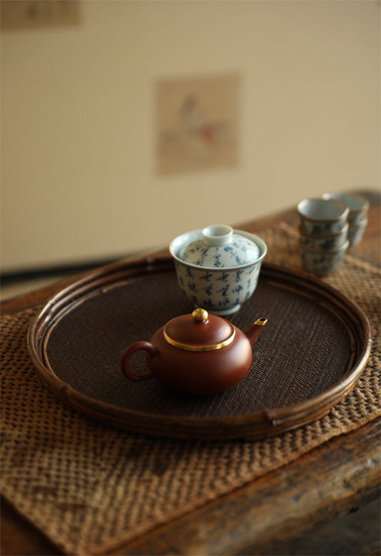 The Kosei Woven Bamboo Tray by Piexlculpt is crafted by hand from natural bamboo, offering two unique finishes: deep purple bamboo and warm brown bamboo. Its circular woven design reflects the calm