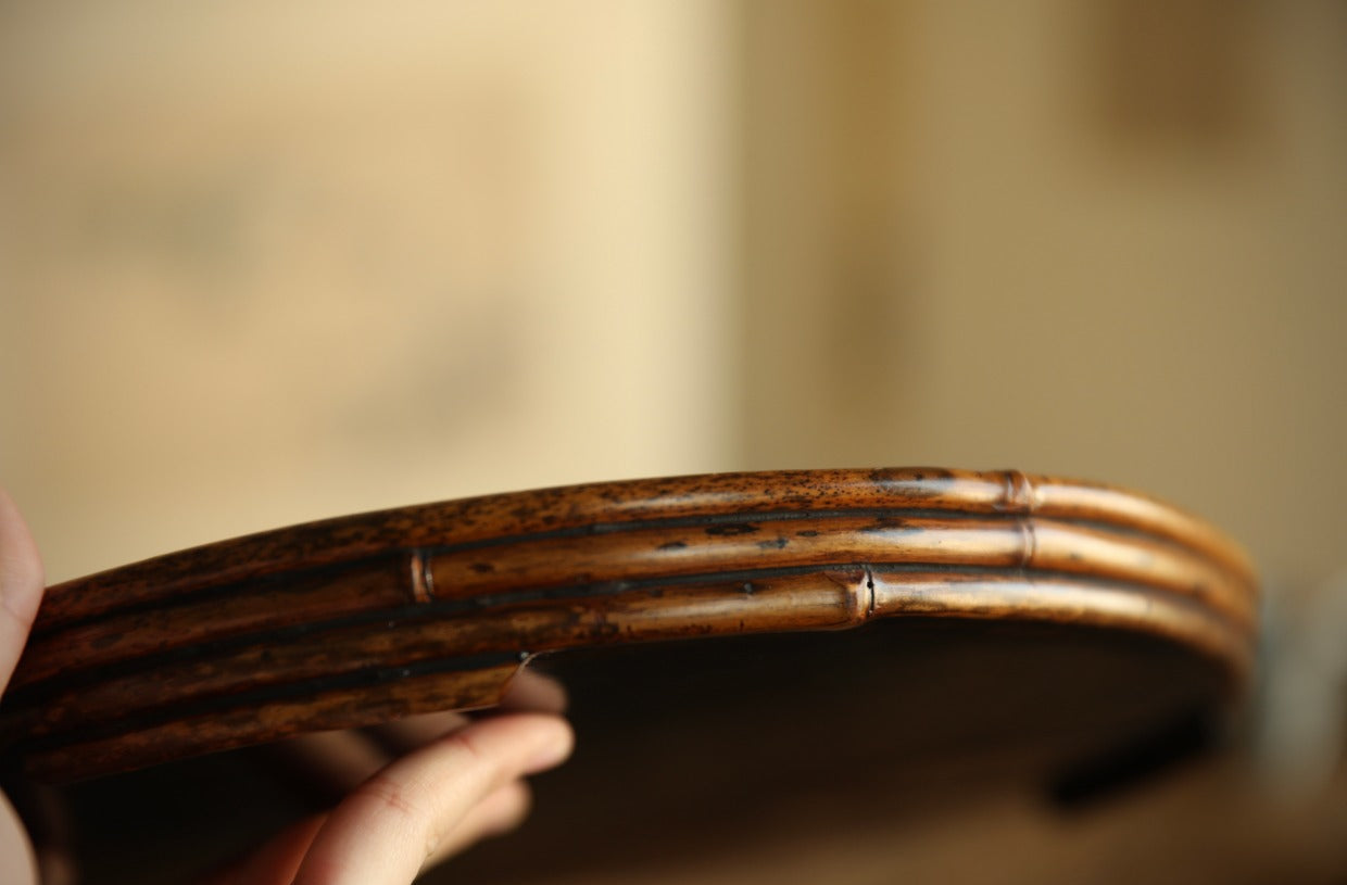 The Kosei Woven Bamboo Tray by Piexlculpt is crafted by hand from natural bamboo, offering two unique finishes: deep purple bamboo and warm brown bamboo. Its circular woven design reflects the calm