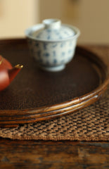 The Kosei Woven Bamboo Tray by Piexlculpt is crafted by hand from natural bamboo, offering two unique finishes: deep purple bamboo and warm brown bamboo. Its circular woven design reflects the calm