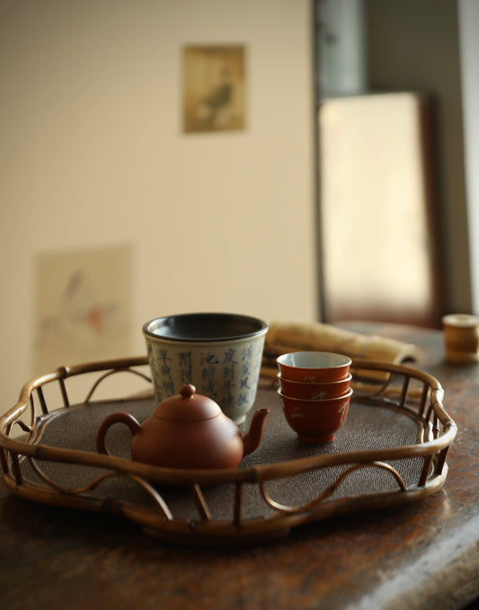 The Shirabe Bamboo Tray by Piexlculpt is a handcrafted tea tray combining purple bamboo and rattan weaving in a plum blossom frame design. Its light yet sturdy form embodies balance and grace