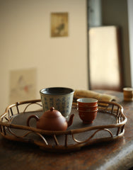 The Shirabe Bamboo Tray by Piexlculpt is a handcrafted tea tray combining purple bamboo and rattan weaving in a plum blossom frame design. Its light yet sturdy form embodies balance and grace